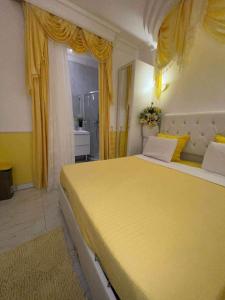 a bedroom with a large yellow bed with yellow curtains at Chambre de luxe 95 Grise in Deuil-la-Barre