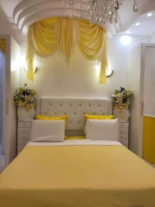 a bedroom with a large yellow bed with yellow curtains at Chambre de luxe 95 Grise in Deuil-la-Barre