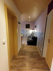 um corredor que leva a um quarto com um sofá em Aparthotel Harlekin em Willingen