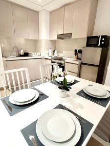 a kitchen with a table with white plates on it at Charming Yas Island Stay with Balcony in Abu Dhabi