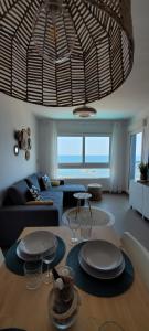 Beachfront Apartment La Manga في لا مانغا ذيل مار مينور: غرفة معيشة مع أريكة وطاولة