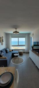 a living room with a blue couch and a table at Beachfront Apartment La Manga in La Manga del Mar Menor
