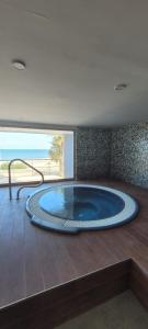 a large hot tub in a room with a view of the ocean at Beachfront Apartment La Manga in La Manga del Mar Menor