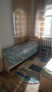 a small bedroom with a bed and a window at Hostel A99 in Astana