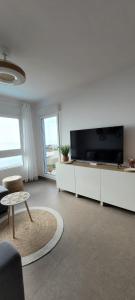 a living room with a tv and a chair and a table at Beachfront Apartment La Manga in La Manga del Mar Menor