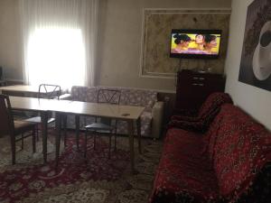 a living room with a couch and a table and a tv at Hostel A99 in Astana