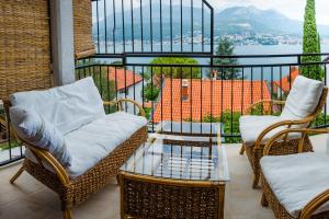 two chairs and a table on a balcony with a view at Zazenda House in Herceg-Novi