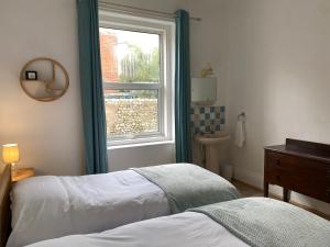 Un dormitorio con una ventana, una cama y un lavabo. en Peaceful Coastal Apartment, en Ventnor