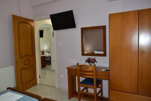 a room with a desk with a mirror and a wooden cabinet at Pansion Pandora in Skiathos