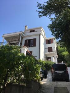 a white house with a car parked in front of it at Zazenda House in Herceg-Novi