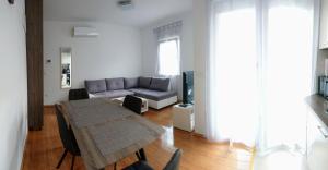 un soggiorno con tavolo e divano di West Star Apartment a Trogir