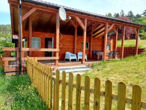 a wooden cabin with a fence in front of it at Domus Mare domek holenderski in Wisełka