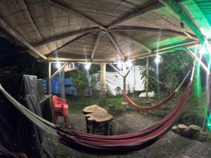 a hammock in a tent with a table and chairs at La cabaña M in Pereira
