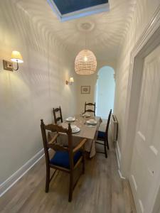 a dining room with a table and chairs and a chandelier at Peaceful Coastal Apartment in Ventnor