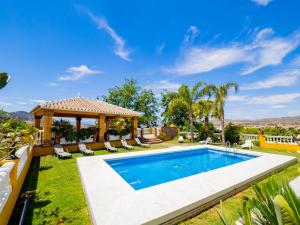 einen Hinterhof mit einem Pool und einem Pavillon in der Unterkunft Cubo's Villa Fina & Minigolf included in Málaga