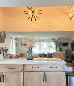 a kitchen and living room with a vase of flowers at Modern Family Home in Middletown, RI- just 4 mi to Newport! in Middletown
