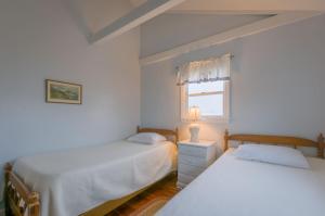 2 camas en un dormitorio blanco con ventana en 80 Salt Marsh Road East Sandwich - Cape Cod, en East Sandwich