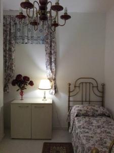 een slaapkamer met een bed, een lamp en een raam bij La Ninfea 