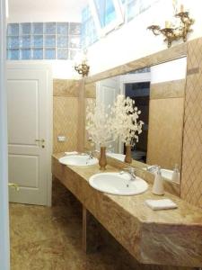 een badkamer met 2 wastafels en een grote spiegel bij La Ninfea 