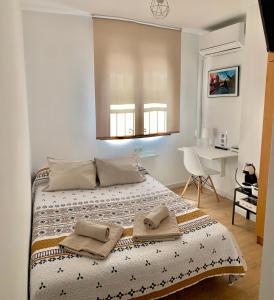 ein Schlafzimmer mit einem Bett mit zwei Handtüchern darauf in der Unterkunft Habitación González in Málaga