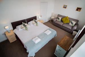 a bedroom with a large bed and a couch at The Torrs Apartments New Mills in New Mills
