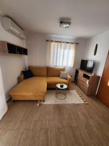 uma sala de estar com um sofá e uma televisão em Lucija em Karlobag