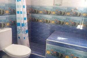 een badkamer met een toilet en wat vis aan de muur bij Θέα in Kamarai +20 foto's