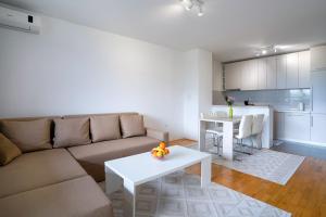 a living room with a couch and a table and a kitchen at Happy apartment Ilidža in Sarajevo