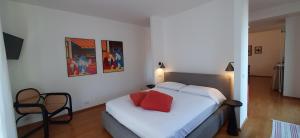 a bedroom with a bed with a red pillow on it at IseoLakeRental - Vacanza Romantica in Riva di Solto +28 photos