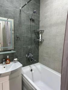 a bathroom with a shower and a tub and a sink at Comfortable 2-roomed apartment Ozod Apartments SU2 in Samarkand