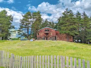 an old house on a hill behind a fence at Hotel Tusheti in Omalo