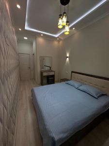 ein Schlafzimmer mit einem Bett und einer Decke mit Licht in der Unterkunft Comfortable 2-roomed apartment Ozod Apartments SU2 in Samarkand