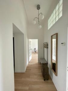 a hallway with white walls and a suitcase on the floor at Appartemment Nimes Arènes in Nîmes