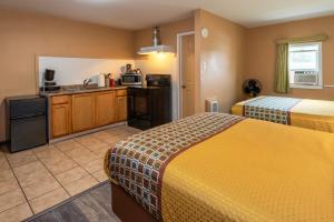 um quarto de hotel com duas camas e uma cozinha em Town Motel em Forks