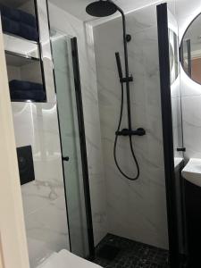 um chuveiro com uma porta de vidro na casa de banho em MK8 Apartment em Bergen