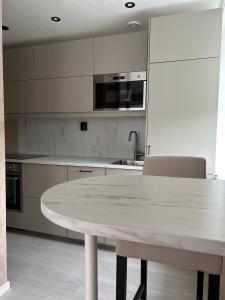 a white kitchen with a table and a sink at MK8 Apartment in Bergen