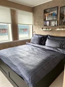 uma cama grande num quarto com 2 janelas em MK8 Apartment em Bergen