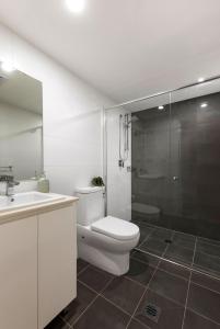 uma casa de banho com um WC, um lavatório e um chuveiro em Kahlo Alexandria - Stylish 2 bdrm Walk to Train em Sydney