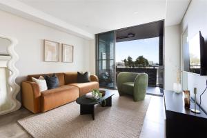 a living room with a couch and a chair at Kahlo Alexandria - Stylish 2 bdrm Walk to Train in Sydney