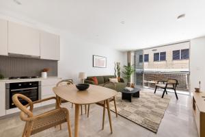 a kitchen and living room with a table and chairs at Kahlo Alexandria - Stylish 2 bdrm Walk to Train in Sydney