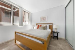 a bedroom with a bed and a window at Kahlo Alexandria - Stylish 2 bdrm Walk to Train in Sydney