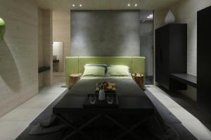 a bedroom with a bed with a green head board at Tonnoconte Relais & Restaurant in Andria