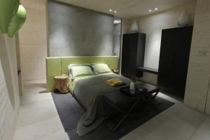 a bedroom with a bed and a table in it at Tonnoconte Relais & Restaurant in Andria