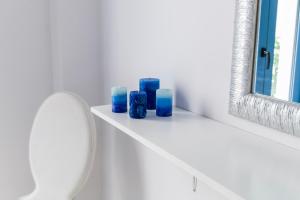 a bathroom with blue candles on a shelf next to a toilet at Porto Bello di Paros in Parikia