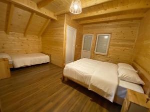 1 dormitorio con 2 camas en una cabaña de madera en Adenisi guesthouse, en Tropojë