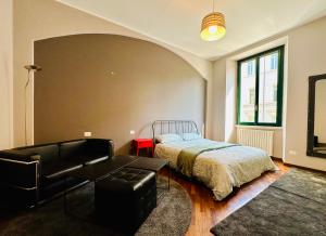 a bedroom with a bed and a couch and a chair at Sweet Apartment Navigli Milano S2 in Milan