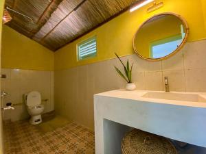 a bathroom with a sink and a mirror and a toilet at Banana Surf House in Arugam Bay