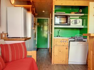 a small kitchen with green walls and a red couch at Studio Les Arcs 1800, 2 pièces, 5 personnes - FR-1-346-426 in Arc 1800