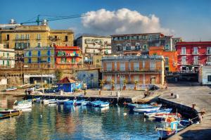 un groupe de bateaux amarrés dans un port avec des bâtiments dans l'établissement Sisina Luxury Room Jacuzzi & Piscina, à Portici