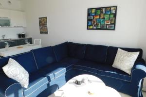 - un canapé bleu dans le salon avec une table dans l'établissement Bright T2 "Golf Panorama" air-conditioned parking golf view, à Biot